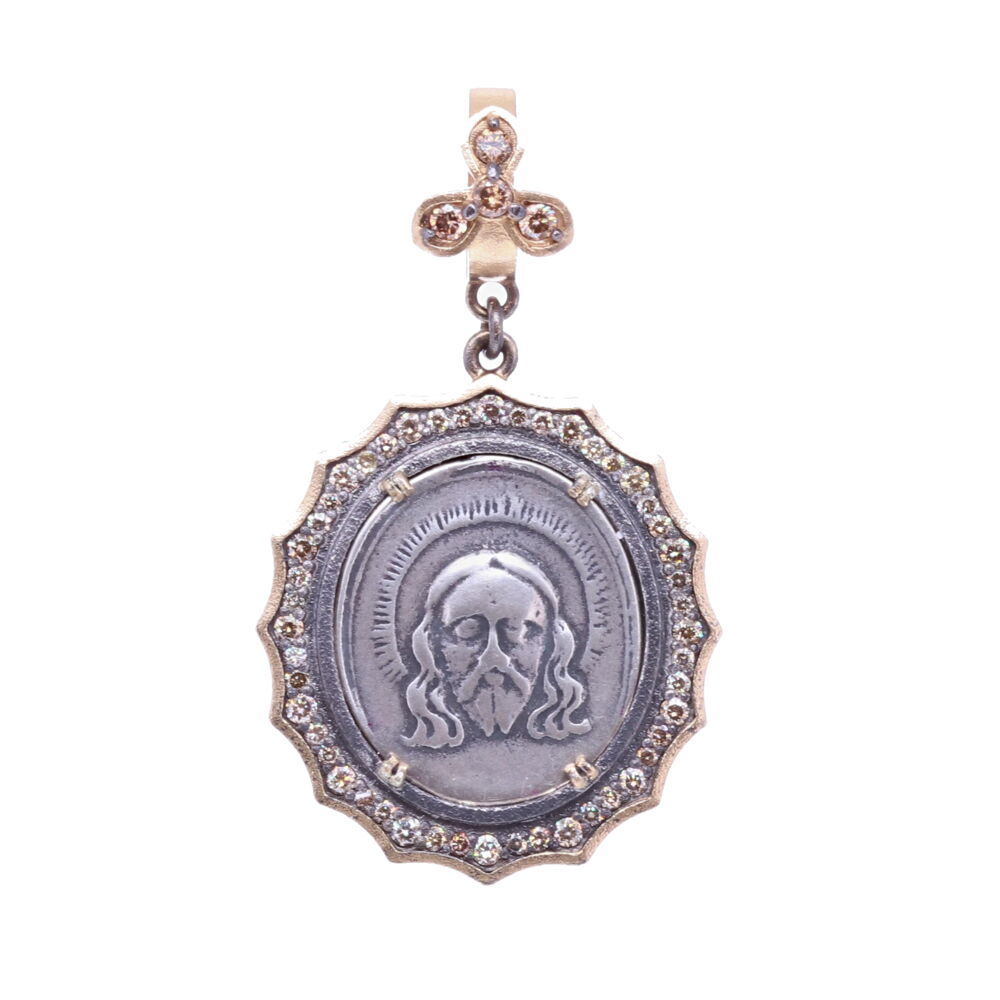 This original 19th Century medal displays Christ on the front and The Lady of Montserrat on the back. This medal is set in a 14k Yellow Gold 3.1g, Rhodium sterling, and Diamond 0.66 tcw bezel.The bale opens to 4mm. Spanish 19th C. Christ and Lady of Montserrat Pendant