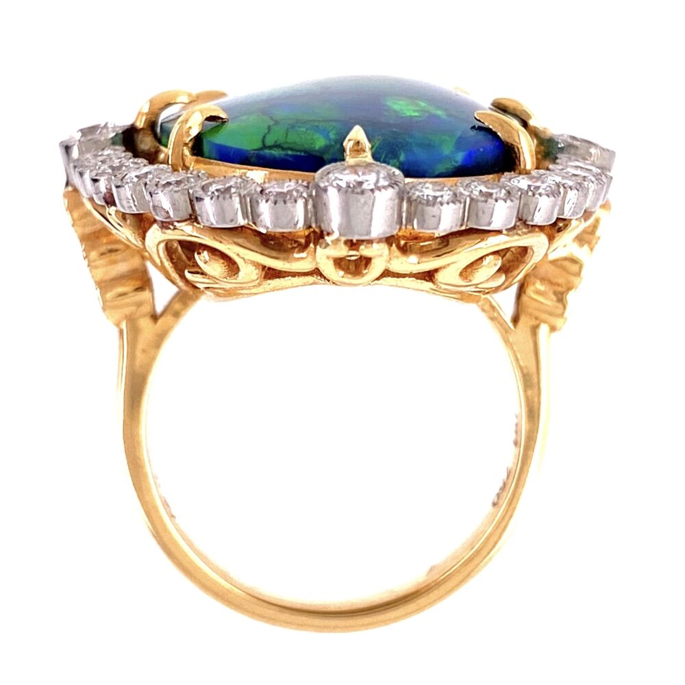 The Lightning Ridge Mine in Australian is famous for it's world renowned supply of fine opal and especially black opal like this museum specimen. The center 18.41ct black opal has amazing play of color(flashes) along with snake skin pattern making it very special! The ring is newer to look old Edwardian style with Platinum topping 18K Yellow Gold and a diamond halo with milgrain work. The diamonds weigh approx. 1.80tcw. Platinum 18.41ct Black Opal & 1.80tcw Diamond Ring 16.9g, s7
