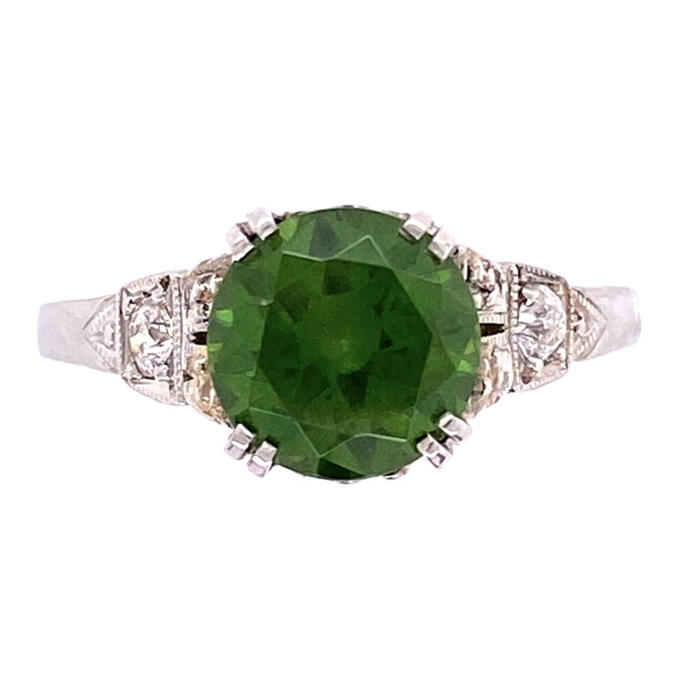 Russian Demantoid Garnets from the URALs are very rare and hard to find, especially over a 1ct in size. This amazing 1.85ct Round Russian Demantoid has multiple classic Horsetail inclusions and has the vibrant green only seen in this stone. The Demantoid is set in a simple, yet classic platinum art deco ring with .12tcw antique cut diamonds. Platinum Art Deco 1.85ct Round Demantoid Garnet Ring 3.3g, s6.5