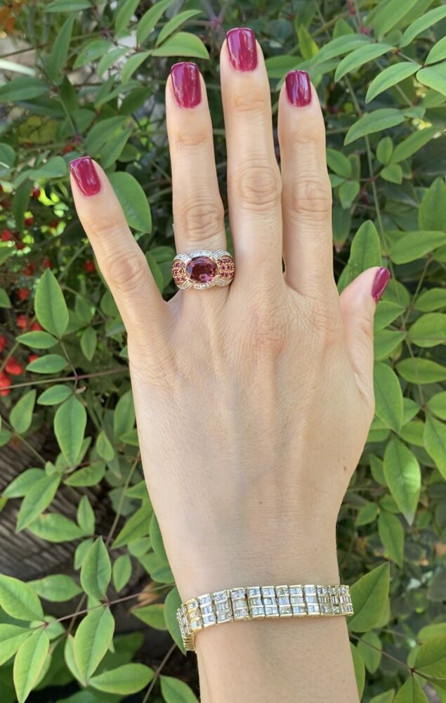 The ring has a center oval pink tourmaline weighing approx. 4ct, side round rubies weighing approx. .72tcw & .08tcw. It is cast and has a finished under gallery. Don't miss this colorful & tremendous value ring! 14K YG Oval Tourmaline, Ruby & Diamond Modern Ring 7.9g, s6.5