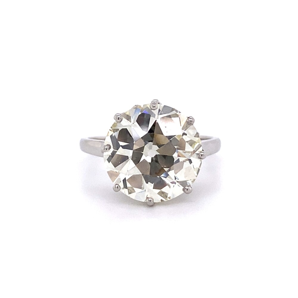 Check out this amazing handmade solitaire with 8 prongs, scroll work and detailing underneath. The main diamond weighs 6.05ct and faces very white like Old European Cut diamonds usually do! Because diamond's color is graded on their side, the true grade is O-P even though it faces much higher color. The stone is completely eye clean, VS clarity judged. 6.05ct Old European Cut Diamond in Platinum Solitaire Ring, s6.5