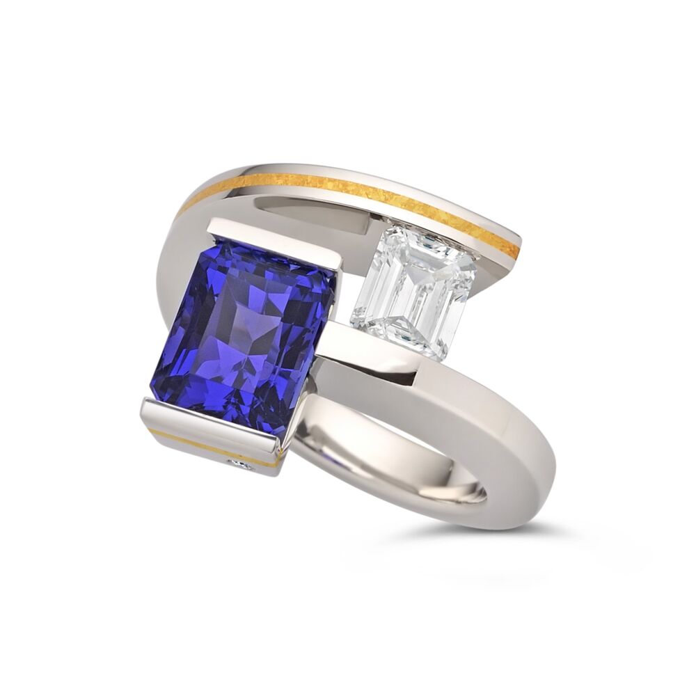 <p>This is a one-of-a kind 2-Stone Helix Ring in platinum with a 24-karat crystallized gold inlay stripe and a hidden diamond melee accent.</p>
<p>The ring features a vivid, intense blue-purple Tanzanite weighing 3.61ct. (9.12 x 6.98 x 6.86mm) and a Tension-set 0.78ct. E/VS2, emerald cut diamond (GIA certificate provided for diamond).</p>
<p>Finger size 52.75, American 6.5. Please note that Tension-set rings have limited size-ability; please contact us for further information.</p> 2-Stone Tanzanite and Diamond Helix Ring