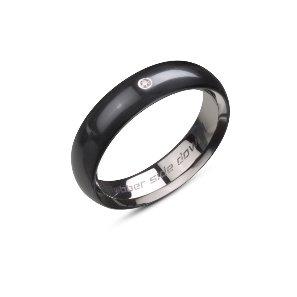 Tire Slick band is available exclusively in Midnight Blue Polarium, our magnetic platinum alloy, includes a single diamond melee and is 6mm wide. This style comes with a standard "Rubber side down!" engraving on the inside of the band that can be omitted or substituted. Please inquire for sizes above a 68. Tire Slick Band Polarium