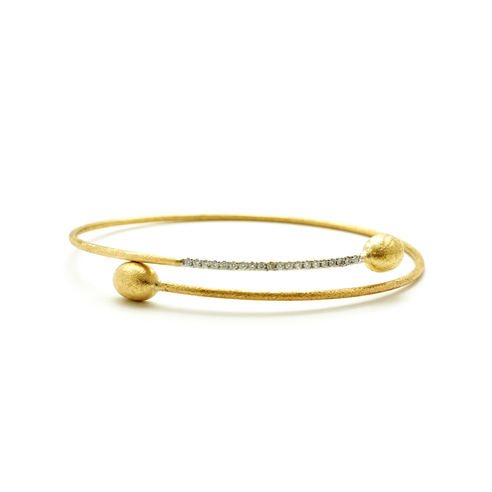 This beautifully bold 18K yellow gold bangle bracelet brought to you by Nanis Fine Jewelry and Italian designer Laura Bicego brings sheer luxury. It features a wire wrap design with gold beads at the ends and 0.15 carat white diamonds set into the top wire. Dancing In The Rain Crossover Bangle Bracelet