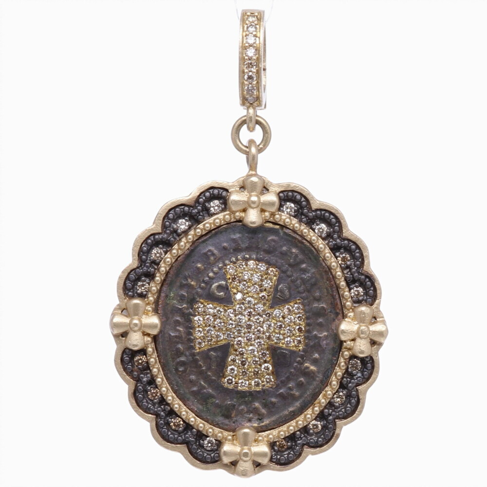 To this day, after 1,400 years after his writing, the St. Benedict Rule is the most common and influential Rule used by monasteries and monks. Carrying a St. Benedict medal provides the ultimate protection from evil. It is one of the oldest and most honored medals used by Christians. The front and center of the medal the monogram "CPSB" stands for the Cross Of Holy Father Benedict. At the top of the medal "IHS" Jesus. Around the cross "V R S N S M V - S M Q L I V B" Begone Satan! Never tempt me with your vanities! What you offer me is evil. Drink the poison yourself! This original one of a kind antiquity is set in a 14k yellow gold 7.06g, champagne diamond 0.52tcw, and rhodium sterling bezel. Cynthia Ann enhanced this medal with diamond shield cross inlay. The brown patina is original. St. Benedict Diamond Shield Pendant
