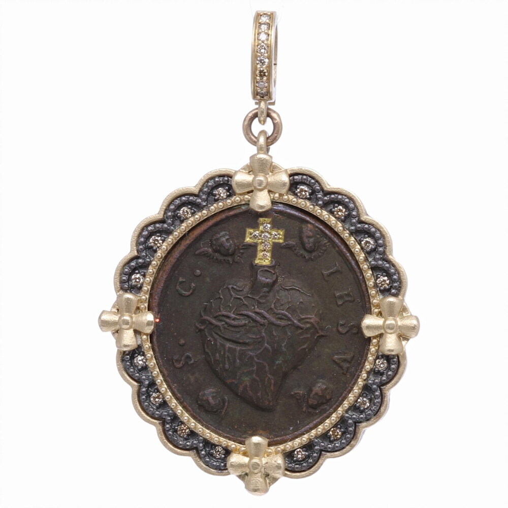 The original Sacred Heart antiquity has a protruding heart encircled in a crown of thorns and surrounded by four Cherubs. The "S. C. IESV" is a Latin monogram referring to Christ. The sacred heart medal has a diamond inlayed cross created by Cynthia Ann. It's set inside a 14k yellow gold 7.45g, diamond 0.243 tcw, and rhodium sterling bezel. Antique Sacred Heart with Cherubs Pendant