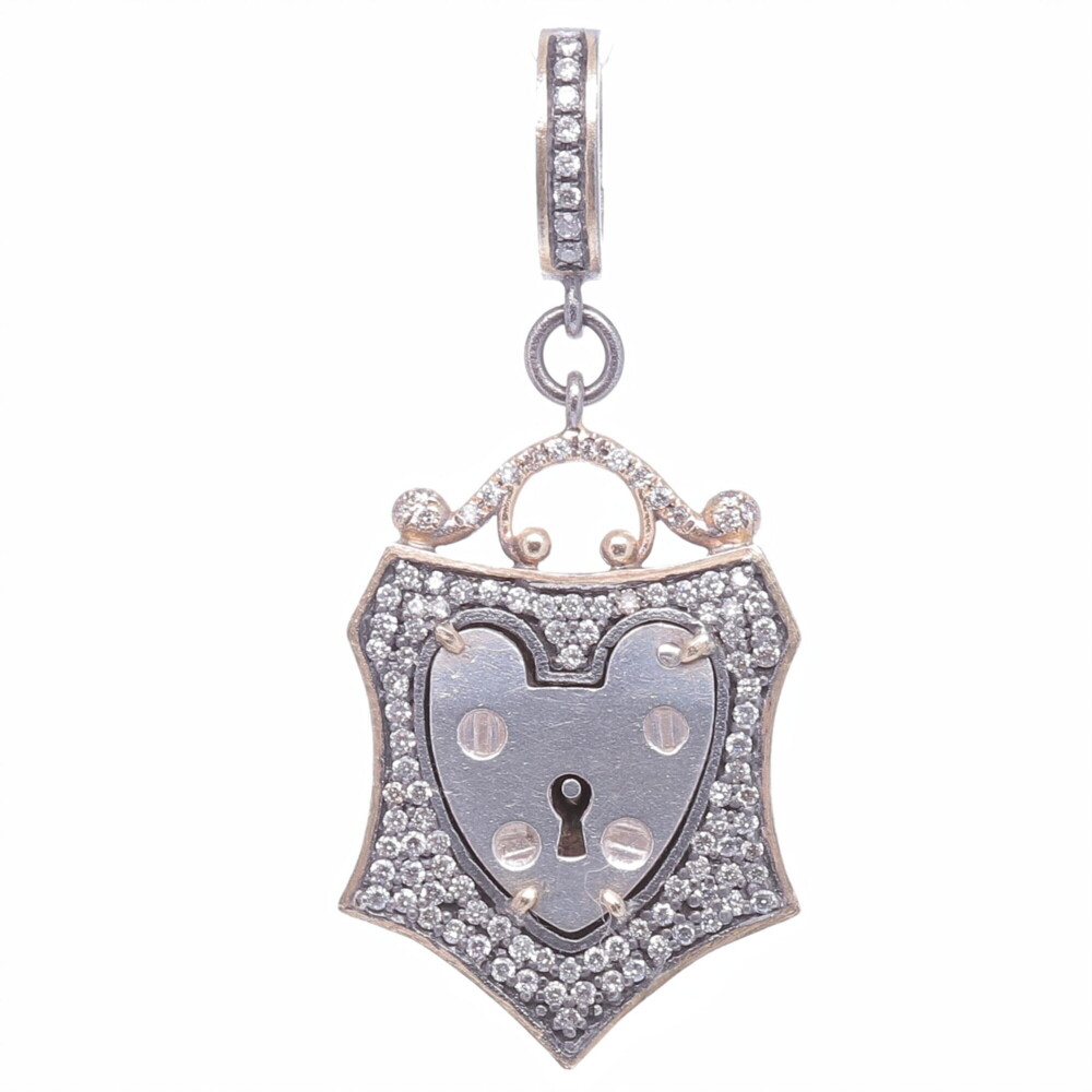 The Antique English padlock was typically worn on a bracelet and given to a loved one to show how much they were loved. Before going off to war, gentlemen would leave the bracelet locked around his loved one’s wrist and he would hold the key until his return. The heart shaped padlock was fashionable in the Victorian and Edwardian periods. This one of a kind English Padlock is set in a Cynthia Ann diamond 0.60 tcw, 14k yellow gold 3.08g, and rhodium sterling bezel. Small Vintage English Padlock Heart Shield