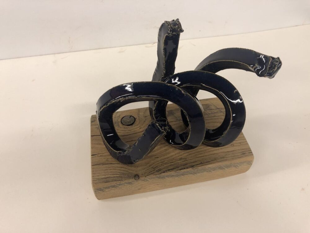 This sculpture by artist Brandon Reese beautifully combines glazed stoneware and oak. Deep Blue Spiral shows that one element can bring out the characteristics of the other. Deep Blue Spiral