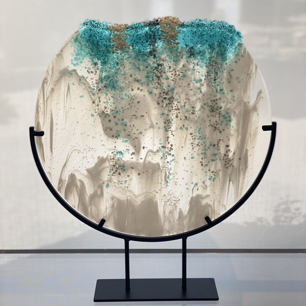 This glass sculpture by artist Carole Perry features crushed aquamarine, silver and white on a clear and white glass. Multnomah Falls in the Winter sits in a black steel stand. Multnomah Falls