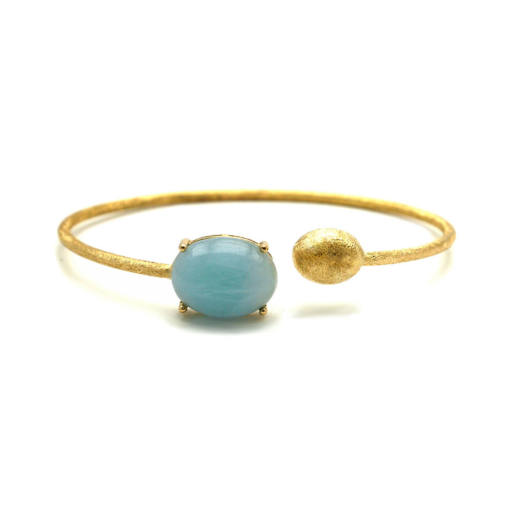 This beautifully bold 18K yellow gold bangle bracelet brought to you by Nanis Fine Jewelry and Italian designer Laura Bicego brings sheer luxury. It features an open wire design with a gold ball at one end and a larger Aquamarine oval cabochon at the other end Dancing In The Rain Large Aquamarine Wrap Bangle Bracelet