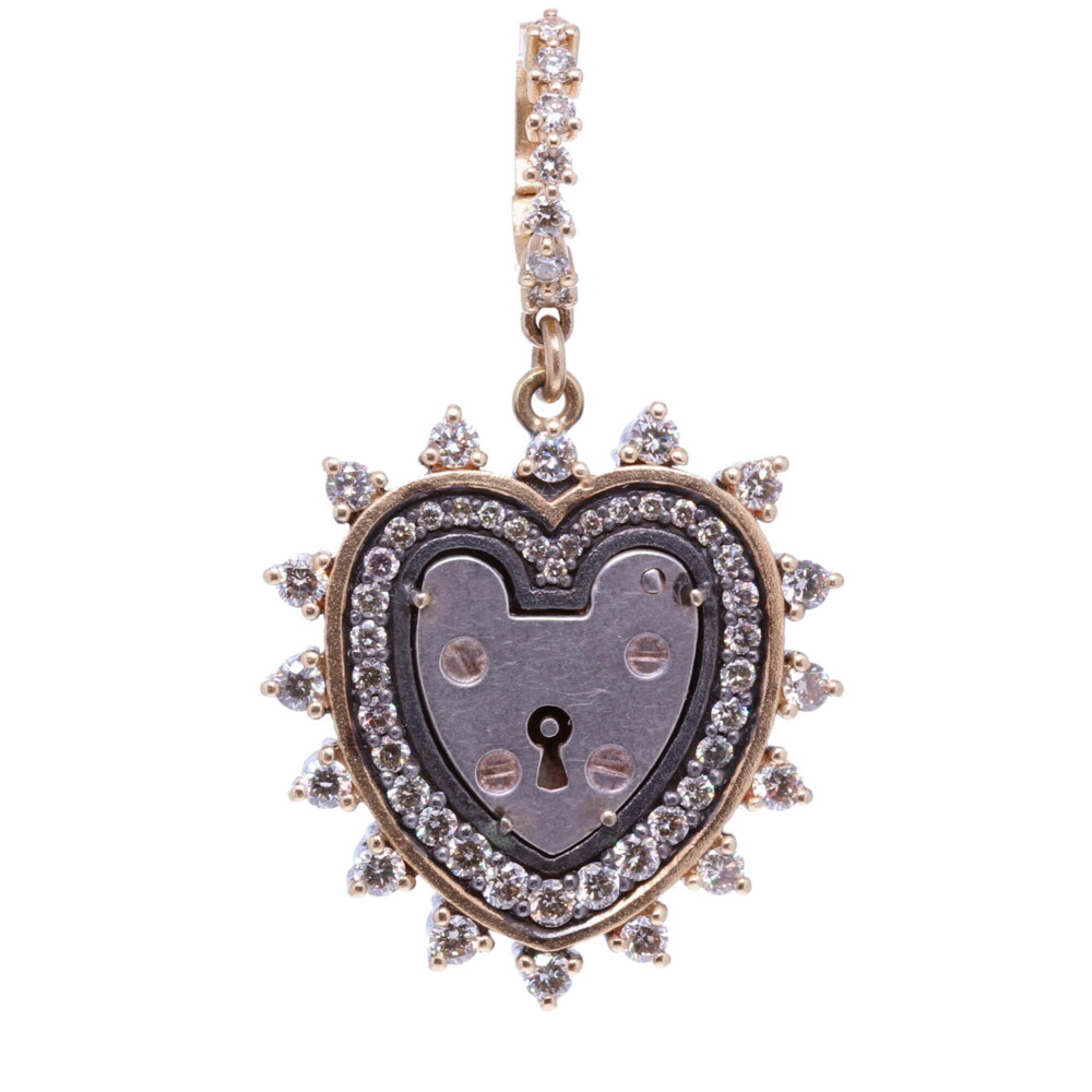 The Antique English padlock was typically worn on a bracelet and given to a loved one to show how much they were loved. Before going off to war, gentlemen would leave the bracelet locked around his loved one’s wrist and he would hold the key until his return. The heart shaped padlock was fashionable in the Victorian and Edwardian periods.
Heart Shaped Vintage Padlock, Surrounded by a Champagne Diamond, 14k Yellow Gold and Black Rhodium 3 Prong Bezel, Hanging from a Champagne Diamond and 14k Yellow Gold Openable Bale.
Champagne Diamond - 1.3tcw
14k Gold - 4.17g
Black Rhodium Silver Heart Shaped Vintage Padlock