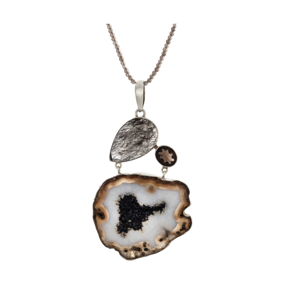 <font style="font-family: "EB Garamond";" size="4"><span style="font-family: "EB Garamond";"><font size="4">Fawn & White Agate Pendant With Black Druze & Tourmalated Quartz Pear & Smoky Quartz Oval</font></span></font><div style="font-family: "EB Garamond";"><font size="4" style="font-family: "EB Garamond";"><font size="4"><font size="4"><span style="font-family: "EB Garamond";">*Chains are sold separate</span></font></font><br style="font-family: "EB Garamond";"></font><div style="position: initial; margin: initial; font-family: "EB Garamond";"><font size="4"><br style="position: initial; margin: initial; font-family: "EB Garamond";"></font></div><div style="position: initial; margin: initial; font-family: "EB Garamond";"><p style="margin: initial; font-variant-numeric: normal; font-variant-east-asian: normal; font-stretch: normal; line-height: normal; font-family: "EB Garamond"; color: rgb(0, 0, 0); position: initial;"><font size="4"><font style="line-height: 22px; position: initial; margin: initial; font-family: "EB Garamond";"><br style="position: initial; margin: initial; font-family: "EB Garamond";">Formed from volcanic activity, a </font><span style="position: initial; margin: initial; font-family: "EB Garamond";"><font style="line-height: 22px; position: initial; margin: initial; font-family: "EB Garamond";">geode </font></span><span style="position: initial; margin: initial; font-family: "EB Garamond";">begins as a gas bubble rising</span></font></p><p style="margin: initial; font-variant-numeric: normal; font-variant-east-asian: normal; font-stretch: normal; line-height: normal; font-family: "EB Garamond"; color: rgb(0, 0, 0); position: initial;"><font style="line-height: 22px; position: initial; margin: initial; font-family: "EB Garamond";" size="4">within lava. Once the lava hardens, the bubble is a void, due to the</font></p><p style="margin: initial; font-variant-numeric: normal; font-variant-east-asian: normal; font-stretch: normal; line-height: normal; font-family: "EB Garamond"; color: rgb(0, 0, 0); position: initial;"><font style="line-height: 22px; position: initial; margin: initial; font-family: "EB Garamond";" size="4">earth's natural process of salt equalization where molten silica then</font></p><p style="margin: initial; font-variant-numeric: normal; font-variant-east-asian: normal; font-stretch: normal; line-height: normal; font-family: "EB Garamond"; color: rgb(0, 0, 0); position: initial;"><font style="line-height: 22px; position: initial; margin: initial; font-family: "EB Garamond";" size="4">methodically fills the gaseous voids. The various colors of geodes are</font></p><p style="margin: initial; font-variant-numeric: normal; font-variant-east-asian: normal; font-stretch: normal; line-height: normal; font-family: "EB Garamond"; color: rgb(0, 0, 0); position: initial;"><font style="line-height: 22px; position: initial; margin: initial; font-family: "EB Garamond";" size="4">determined by trace minerals present within each pocket. The cooling</font></p><p style="margin: initial; font-variant-numeric: normal; font-variant-east-asian: normal; font-stretch: normal; line-height: normal; font-family: "EB Garamond"; color: rgb(0, 0, 0); position: initial;"><font style="line-height: 22px; position: initial; margin: initial; font-family: "EB Garamond";" size="4">process will determine the size of crystals that form. The slower the</font></p><p style="margin: initial; font-variant-numeric: normal; font-variant-east-asian: normal; font-stretch: normal; line-height: normal; font-family: "EB Garamond"; color: rgb(0, 0, 0); position: initial;"><font style="line-height: 22px; position: initial; margin: initial; font-family: "EB Garamond";" size="4">temperature drops, the larger the crystals become. If the bubble fills</font></p><p style="margin: initial; font-variant-numeric: normal; font-variant-east-asian: normal; font-stretch: normal; line-height: normal; font-family: "EB Garamond"; color: rgb(0, 0, 0); position: initial;"><font style="line-height: 22px; position: initial; margin: initial; font-family: "EB Garamond";" size="4">fully, it is referred to as an agate.</font></p></div></div> Fawn & White Agate Pendant With Black Druze & Tourmalated Quartz Pear & Smoky Quartz Oval