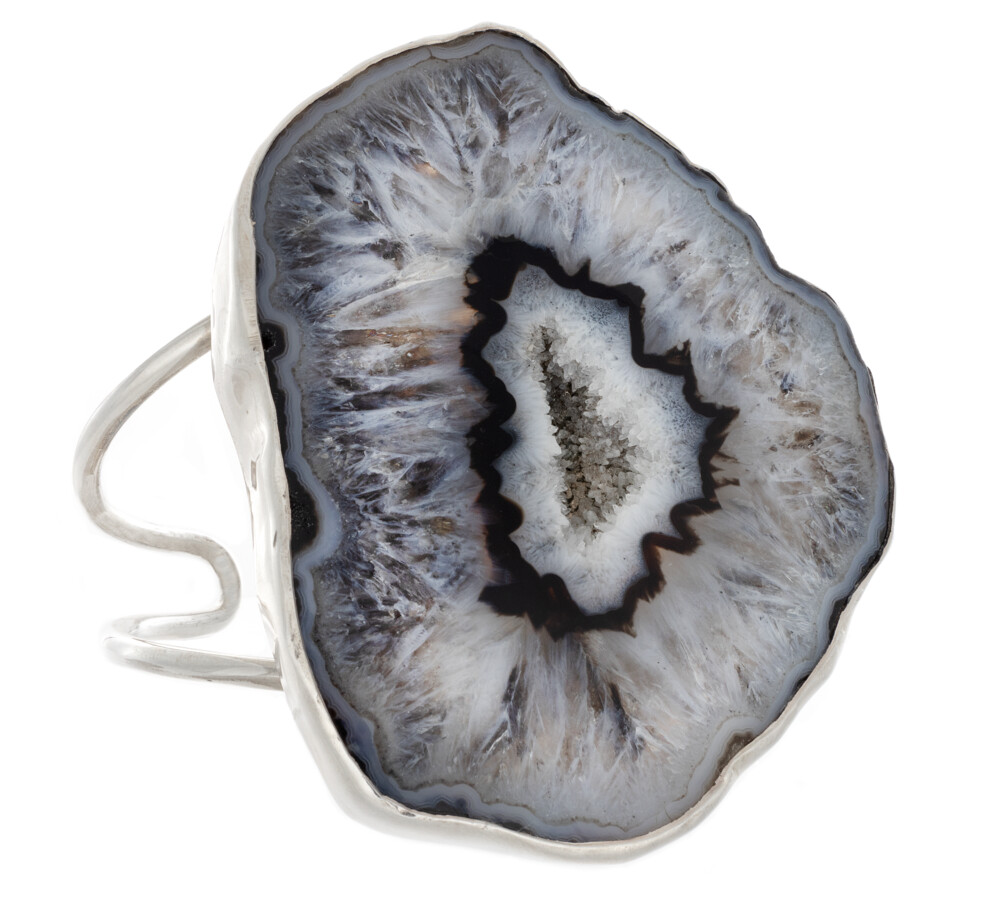 <font size="4"><span style="font-family: "EB Garamond";"><font size="4">Black Agate Druze Geode Cuff - Quartz Crystal Bands</font></span></font><div style="position: initial; margin: initial; font-family: "EB Garamond";"><font size="4"><br style="position: initial; margin: initial; font-family: "EB Garamond";"></font></div><div style="position: initial; margin: initial; font-family: "EB Garamond";"><p style="margin: initial; font-variant-numeric: normal; font-variant-east-asian: normal; font-stretch: normal; line-height: normal; font-family: "EB Garamond"; color: rgb(0, 0, 0); position: initial;"><font size="4">Formed from volcanic activity, a </font><span style="font-size: 0.875em; position: initial; margin: initial;"><font size="4">geode </font></span><span style="font-size: 1.2rem;">begins as a gas bubble rising</span></p><p style="margin: initial; font-variant-numeric: normal; font-variant-east-asian: normal; font-stretch: normal; line-height: normal; font-family: "EB Garamond"; color: rgb(0, 0, 0); position: initial;"><font size="4">within lava. Once the lava hardens, the bubble is a void, due to the</font></p><p style="margin: initial; font-variant-numeric: normal; font-variant-east-asian: normal; font-stretch: normal; line-height: normal; font-family: "EB Garamond"; color: rgb(0, 0, 0); position: initial;"><font size="4">earth's natural process of salt equalization where molten silica then</font></p><p style="margin: initial; font-variant-numeric: normal; font-variant-east-asian: normal; font-stretch: normal; line-height: normal; font-family: "EB Garamond"; color: rgb(0, 0, 0); position: initial;"><font size="4">methodically fills the gaseous voids. The various colors of geodes are</font></p><p style="margin: initial; font-variant-numeric: normal; font-variant-east-asian: normal; font-stretch: normal; line-height: normal; font-family: "EB Garamond"; color: rgb(0, 0, 0); position: initial;"><font size="4">determined by trace minerals present within each pocket. The cooling</font></p><p style="margin: initial; font-variant-numeric: normal; font-variant-east-asian: normal; font-stretch: normal; line-height: normal; font-family: "EB Garamond"; color: rgb(0, 0, 0); position: initial;"><font size="4">process will determine the size of crystals that form. The slower the</font></p><p style="margin: initial; font-variant-numeric: normal; font-variant-east-asian: normal; font-stretch: normal; line-height: normal; font-family: "EB Garamond"; color: rgb(0, 0, 0); position: initial;"><font size="4">temperature drops, the larger the crystals become. If the bubble fills</font></p><p style="font-variant-numeric: normal; font-variant-east-asian: normal; font-stretch: normal; line-height: normal; font-family: "EB Garamond"; color: rgb(0, 0, 0); position: initial; margin: initial;"><font size="4">fully, it is referred to as an agate.</font></p></div> Black Agate Druze Geode Cuff - Quartz Crystal Bands