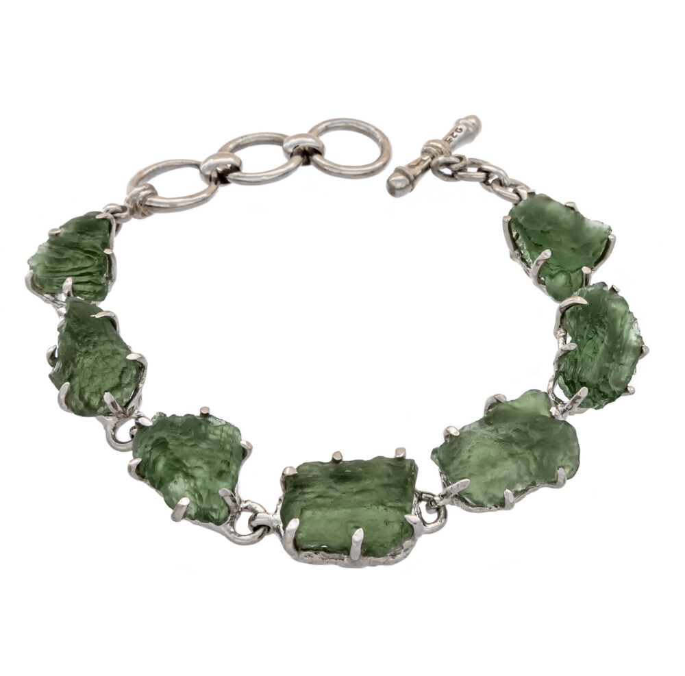 <span style="font-family: "EB Garamond"; position: initial; margin: initial;"><font style="position: initial; margin: initial; font-family: "EB Garamond";" size="4">Moldavite Rough Link Bracelet - Prong Set W. Hammered Silver Bezel & Toggle Clasp Rhodium Plated</font></span><div style="position: initial; margin: initial; font-family: "EB Garamond";"><span style="color: rgb(0, 0, 0); font-family: "EB Garamond"; white-space: pre-wrap; position: initial; margin: initial;"><font style="font-family: "EB Garamond";" size="4">Moldavite is a very intriguing and powerful crystal. It was created by a massive meteorite impact in the Czechoslovakia region around 15 million years ago! Moldavite is often experienced as a tingling in the hand that spreads to the whole body, and many feel an intense heat when holding or wearing it for the first time. With colors ranging from olive to forest green to blue-green, this highly energetic stone is known to hold a very high vibration and to be a powerful aid in healing. Coupled with other crystals, moldavite can raise their vibrations and create an even more potent overall healing vibration. This crystal is an amazing tool for spiritual growth, as well as connecting one to other worlds and dimensions. Using moldavite in meditation can help stimulate and awaken psychic abilities, and it is also a powerful source of protection from any negative or imbalanced energies. A stone of rapid shifts and transformation, moldavite makes an excellent crystal companion for anyone on the path of spiritual awakening!</font></span><span style="font-family: "EB Garamond"; position: initial; margin: initial;"><font size="4" style="position: initial; margin: initial;"><br style="position: initial; margin: initial;"></font></span></div> Moldavite Rough Link Bracelet - Prong Set W. Hammered Silver Bezel & Toggle Clasp Rhodium Plated