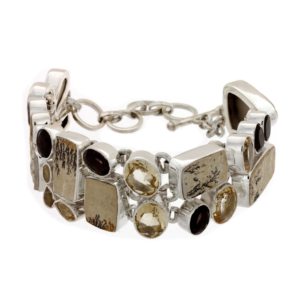 <font size="4"><span style="font-family: "EB Garamond";"><font size="4" style="font-family: "EB Garamond";"><span style="font-family: Lanae;"><font size="4">Dendritic Sandstone Bracelet with Citrine & Smoky Quartz. This beautiful bracelet puts the leaf-like beauty of Dendritic Sandstone on display surrounded by brilliant Citrine and Smokey Quartz. Set in 925 Sterling Silver, this bracelet is a monument of natural Beauty and Stunning jewelry work.</font></span></font></span></font> Dendritic Sandstone Bracelet With Citrine & Smoky Quartz