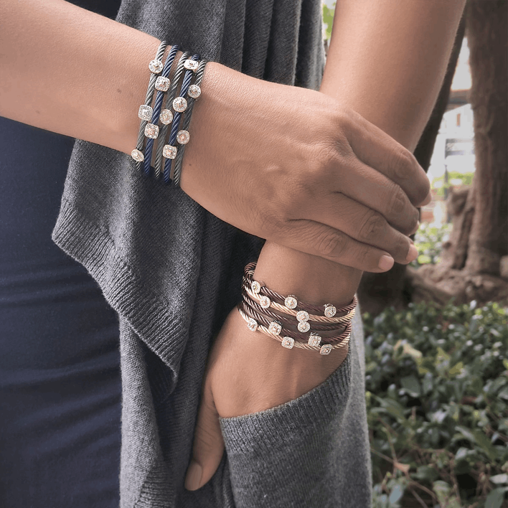 This heat treated steel grey colored steel cable features a thicker circled band with a square diamond station made of 18k white gold; with a total carat weight of .05cts.
Steel Grey Single Squared Station Bangle