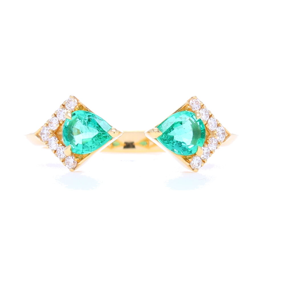 Pear shaped Zambian Emeralds face off in a split front ring set in 18 carat yellow gold with diamond details. This ring can be worn as a stack or on it's own. It's hard not to appreciate the contemporary look and feel of this ring. Rival Zambian Emerald Two Stone Ring with Diamonds