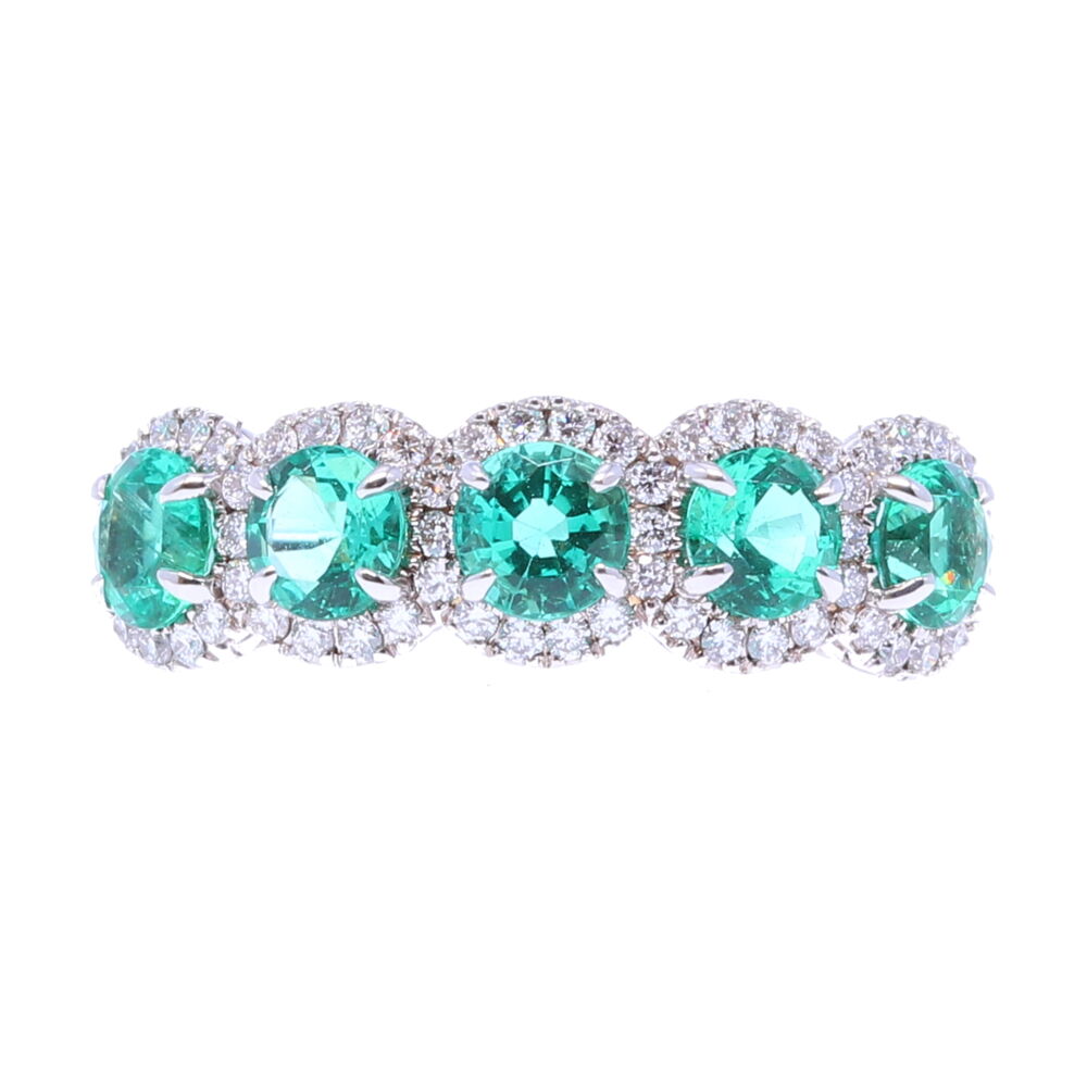 This 18k white gold ring has five emeralds each one with a halo of diamonds circling it. 5 Emerald Stone Halo Ring