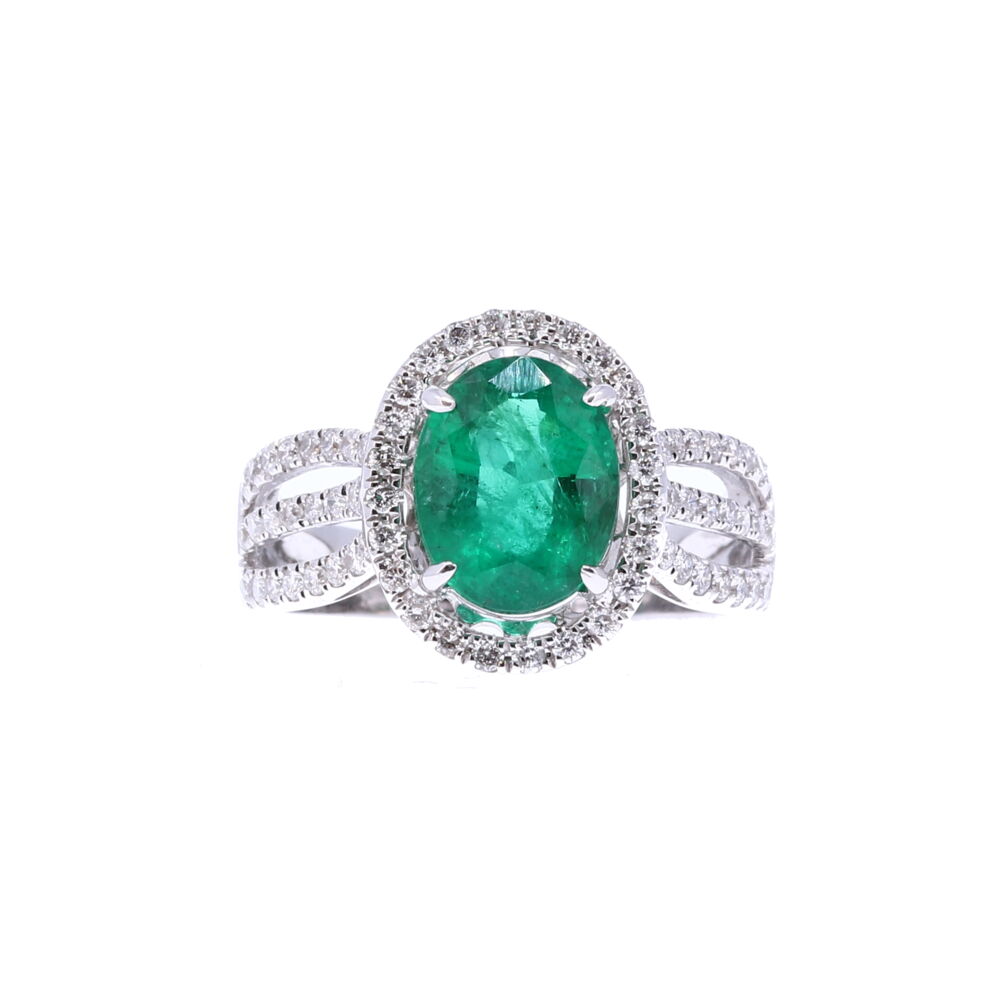 A stunning 2.61 carat emerald set in an an oval 18k white gold claw setting. Surrounding this gorgeous no oil emerald is a halo of diamonds totaling .56 carats. The diamonds drip onto the setting; completely covering the top of the ring. Oval Zambian Emerald Halo Set Ring