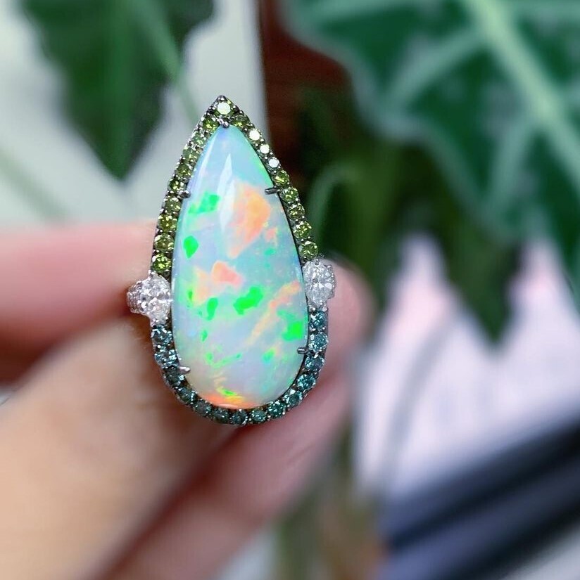 <div>With their fiery brilliance, opals are always an instant hit. Apart from the already impressive 9.32 carat opal, blue, green and white diamonds add to the grandeur of this ring. Diamond weight totals 1.27cts.</div><div>Size 7.</div> Teardrop Opal Ring 18k Gold with Diamonds
