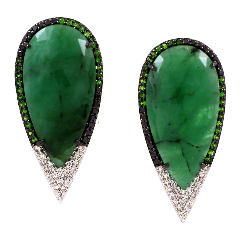 White diamonds are just the tip of the iceberg, figuratively and literally, with these wonderful earrings. Created in 18k White Gold, an astonishing 24.63 carats of raw emeralds are surrounded by white and black diamonds, and tsavorite to add a final splash of green.<div>Diamond weight: 0.77cts</div> Emerald Earrings 18k Gold with Diamonds and Tsavorite