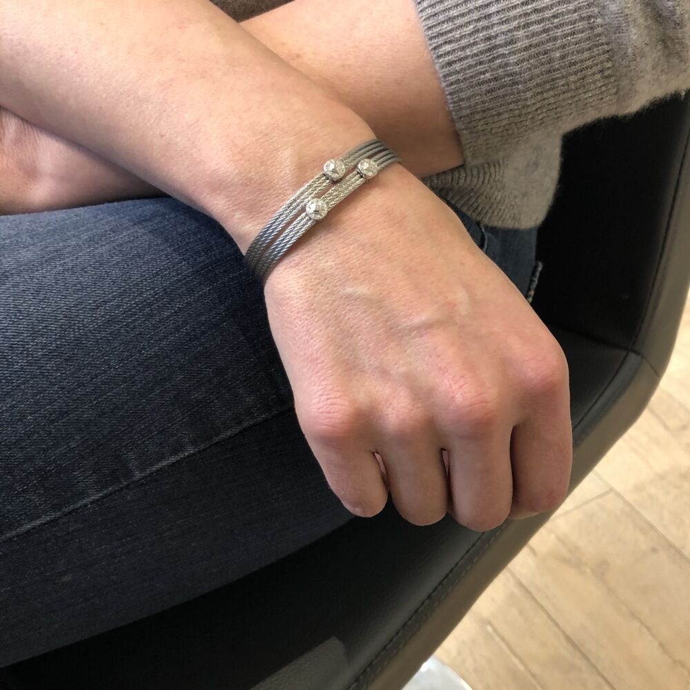 This heat treated grey colored steel cable features three strands of cable. Displaying two circle 18k white gold diamond stations with a total carat weight of .09 carats. This lightweight bangle is perfect to stack with other's from the Alor collection, or to wear alone. Classique Two Circled Station Bangle