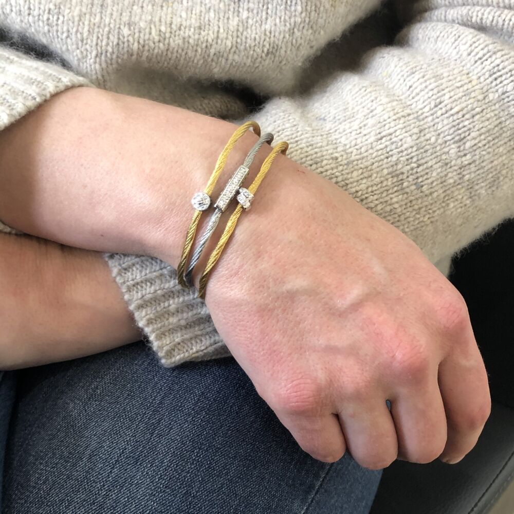 This heat treated yellow colored steel cable features an 18k white gold diamond station with a total diamond weight of .13cts. This adjustable bangle is a one size fits all!
Adjustable Single Station Bangle