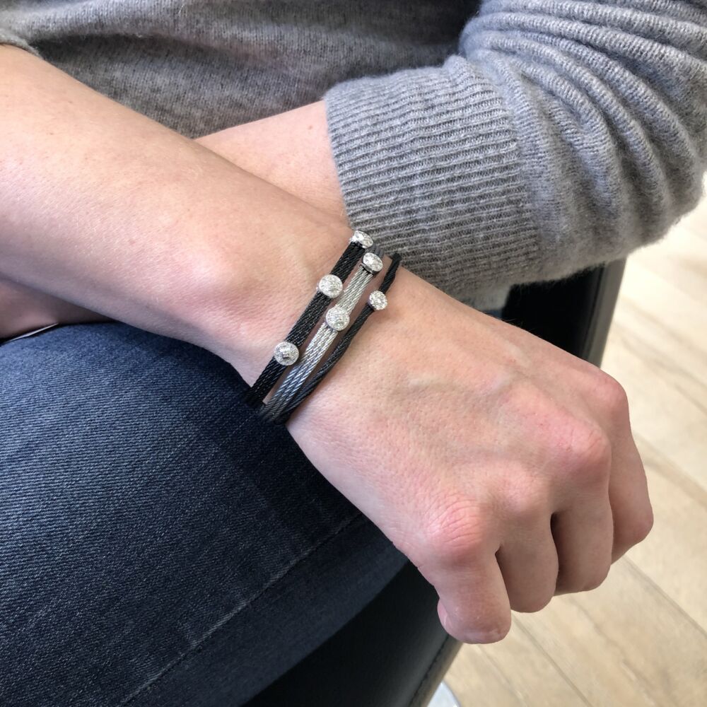<div>Noir heat treated steel cable, features an open design, made to fit all wrists. Displaying an 18k white gold circular diamond setting, with a total weight of .15 carats. This bangle is perfect to stack with others, or find a simple elegance and wear it alone.</div> Noir Adjustable Circle Station Bangle