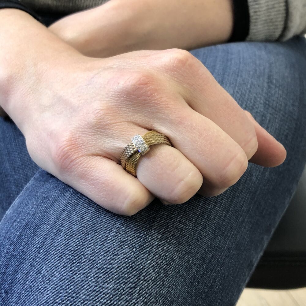 This heat treated carnation and yellow colored steel cable ring, features a 18k white gold diamond station displaying a total carat weight of .16 carats. This lightweight ring is excellent for all day wear, and it transitions into the evening perfectly, matching anything you could think of. Criss-Cross Band Ring