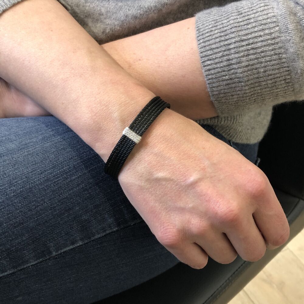 This noir heat treated steel cable cuff features five strands of cable displaying an 18k white gold diamond bar setting, with a total carat weight of .19 carats. This simple yet elegant cuff will make any day an affair. Noir Stacked Cuff